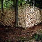 Installation in a forest made from wood for the Arts Festival. 10 meter x 2 meters high. La Fete de Mai, Belgium.